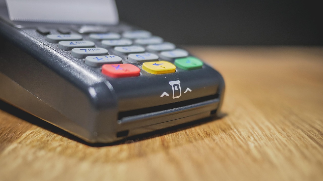 Immagine di un commerciante che utilizza un terminale POS per elaborare un pagamento.