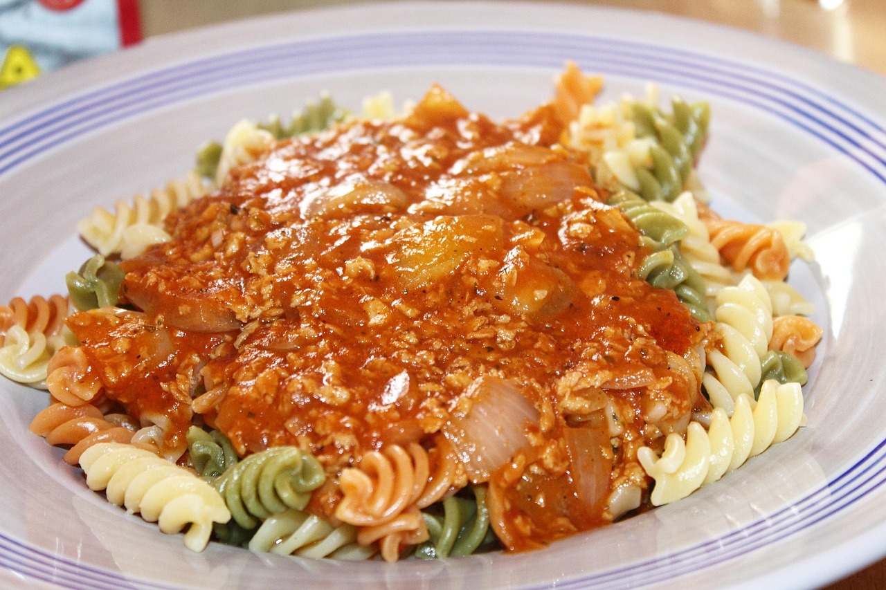 Pasta al ragù di ceci servita in un piatto, decorata con erbe fresche.